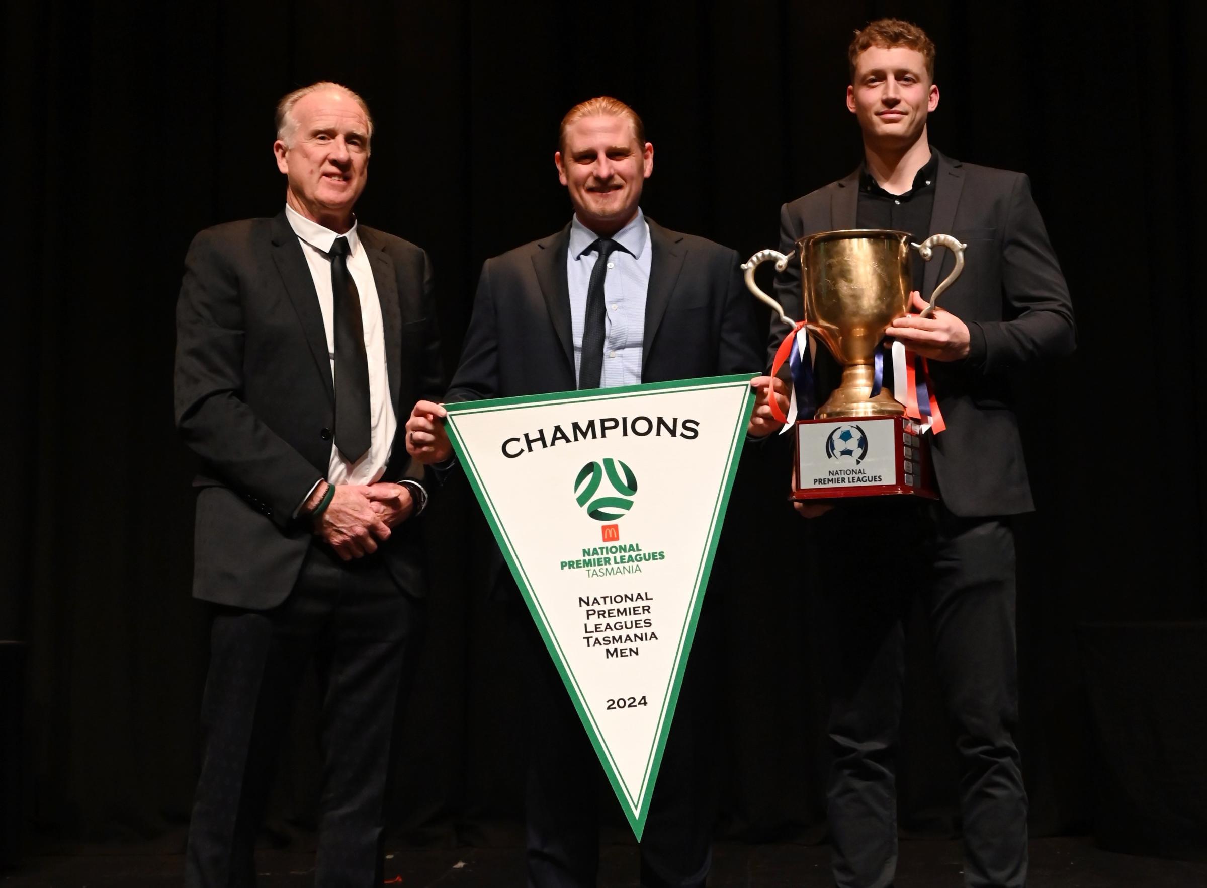 John Barry Murphy, James Sherman and a Glenorchy Knights player with the 2024 NPL Tasmanian winners pennant and cup.