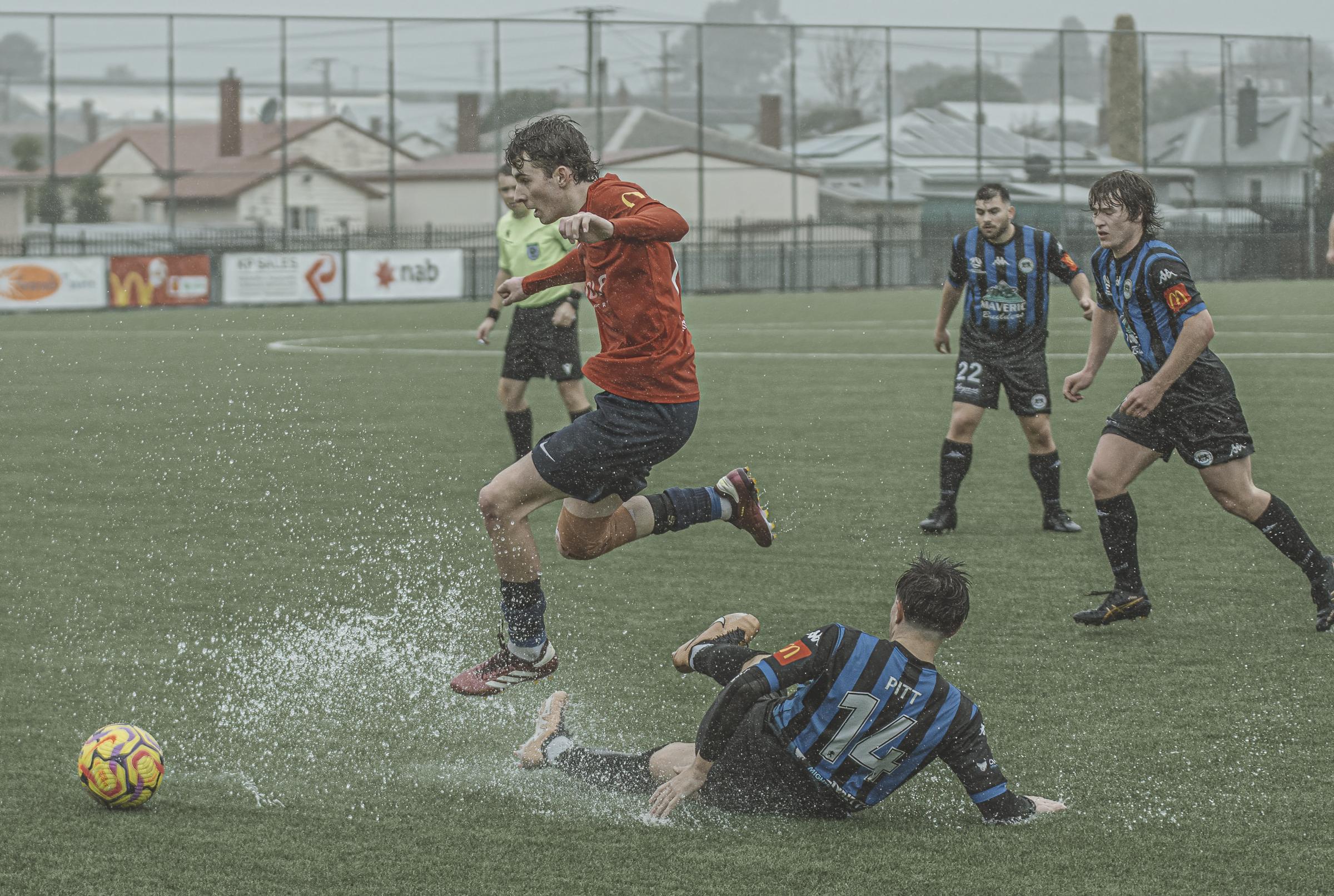 South Hobart's Eli Wright jumps a sliding tackle from Kingborough's Rowan Pitt. Picture by Nikki Long