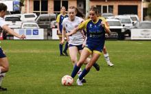 Two women vying for the football 