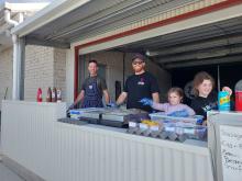 Two men and two girls working on the bbq at Kitchen Centre Park
